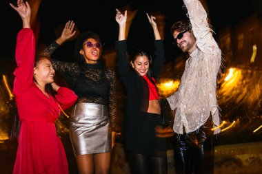 Neşeli çoklu etnik gruptan arkadaşlar gece parti yapıyor. İki Kafkasyalı, bir zenci ve bir Asyalı dans ediyor..