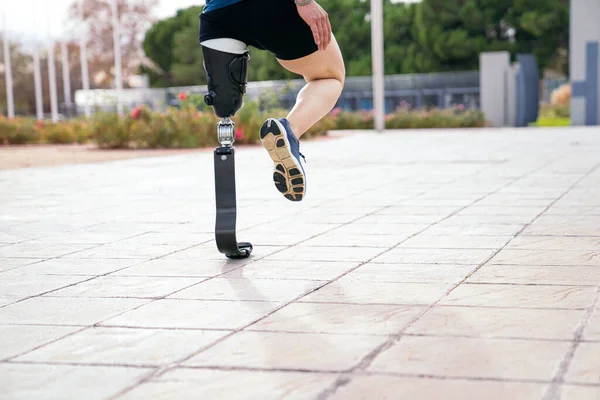 An athlete with a prosthetic leg is captured mid-stretch on a sunlit path, showcasing the fusion of human spirit and advanced technology.