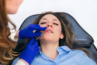 Estetik uzmanı üst dudağı dikkatlice büyüterek doğal ve tanımlanmış bir somurtma için hyalürik asit enjekte eder..