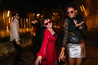 Geceleri dışarıda dans eden bir grup neşeli arkadaş. Hafif boya, canlı parti atmosferini yakalar..