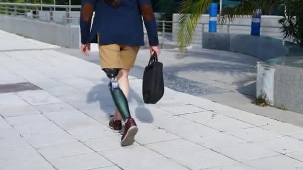 義足のマルチタスクを着て 携帯電話を歩き 都市部でトロリーを運んでいました — ストック動画