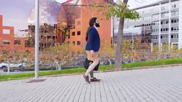現代建築を備えた都市部を歩きながら自信を持って歩く義足とビームの笑顔を持つ起業家 — ストック動画