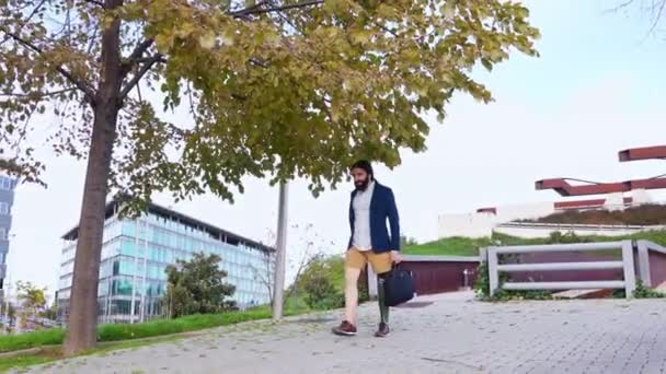 在宁静的公园里 一个有自信的男人 有一条假腿 穿着时髦的衣服 走在一条鹅卵石铺就的小径上 — 图库视频影像