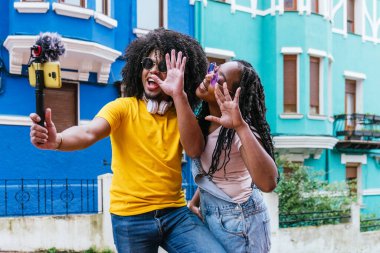 Enerjik arkadaşlar renkli bir şehir ortamında canlı yayın oturumunun keyfini çıkarıyorlar.