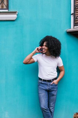 Genç adam pencerenin yanındaki telefon görüşmesinden zevk alıyor..