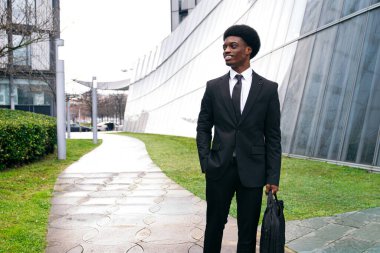 Neşeli afrikalı iş adamı dışarıda rahatça yürüyor..