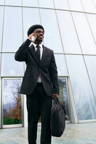 Young African man in a suit handles a business call with poise.