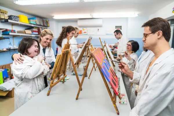 Artists with Down Syndrome share laughs and joy while engaging in an art class.