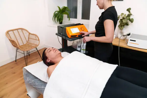 Relaxed patient experiencing an electrotherapy session in a serene clinic.