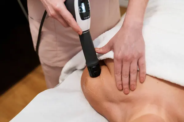 Expert administers targeted shockwave therapy to treat shoulder pain.