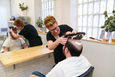 Peruk takmak için yapışkan şerit yerleştirme.