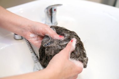 Uzman parmak masajı şampuanı bir saç protezine