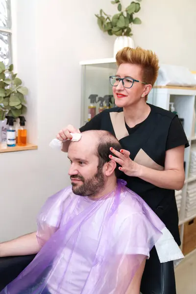 顧客は毛の取り外しの後で注意深い頭皮のクリーニングを受け取ります — ストック写真