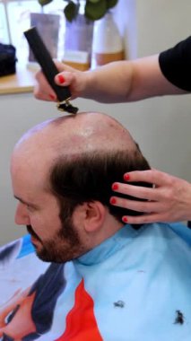 Uzman peruk takmadan önce kalan saçı keser.
