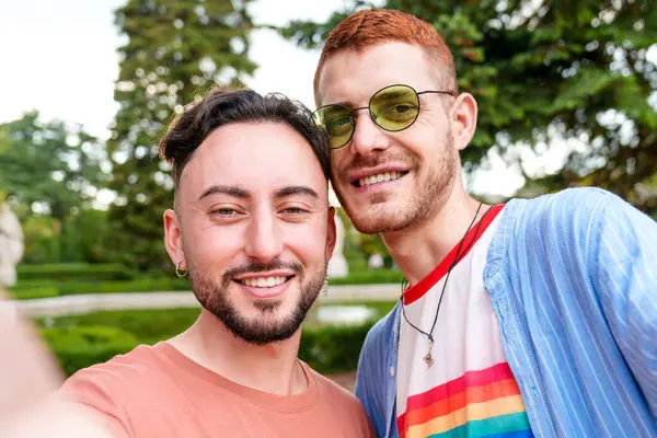 男同性恋 双性恋和变性者夫妇充满活力的自拍记录了他们在公园里快乐的结合 图库图片