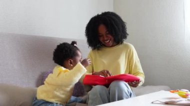 Genç Afrikalı anne ve bebeği oyuncak tıbbi malzemelerle oynayıp eğlenceli ve eğitici bir an yaratıyorlar..