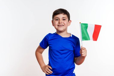 Genç bir çocuk İtalya bayrağı taşıyor. Gülümsüyor ve kameraya bakıyor. Ülkenizde vatanseverlik ve gurur kavramı