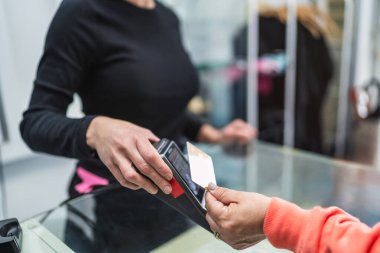 Bir müşteri kredi kartını ödeme için kuafördeki resepsiyoniste veriyor. Salon işlemleri ve nakit ödeme kavramı.