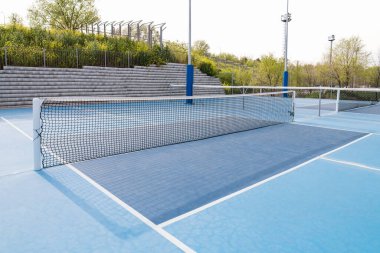 Çevresi yeşillik ve ağaçlarla çevrili mavi bir sahada, bir yankesicinin yakın görüntüsü. Spor malzemesi kavramı.