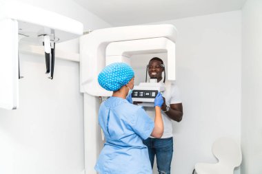 Bir diş hijyenisti, klinikteki üç boyutlu görüntüleme işlemi sırasında hastaya yardımcı olur. Detaylı ağız taramalarını kaydeder. Diş bakımı ve teknolojik hassasiyet kavramı.