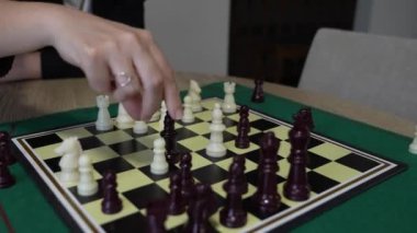 İki çocuk satranç oynuyor. Çocuklardan biri beyaz bir gömlek giyiyor. Diğer çocuk beyaz gömlek ve şort giyiyor.