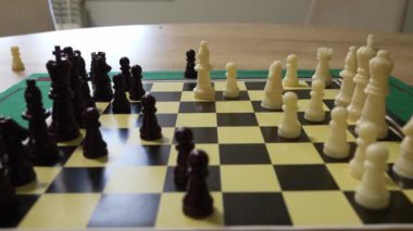 İki çocuk satranç oynuyor. Çocuklardan biri beyaz bir gömlek giyiyor. Diğer çocuk beyaz gömlek ve şort giyiyor.