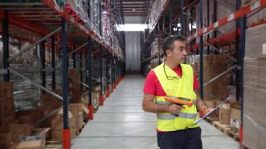 Depo çalışanı, envanteri yavaş çekimde barkod tarayıcısıyla tarıyor. Lojistik ve verimlilik gösteriyor.