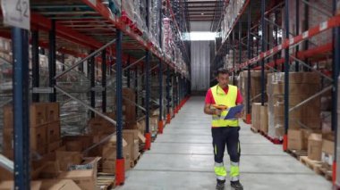 Depo çalışanı barkod tarayıcısı kullanarak ağır çekimde modern ve organize bir depoya giriyor.