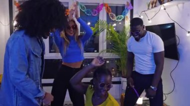 Çok ırklı bir grup arkadaş bir ev partisinde karaoke yaparken eğleniyor, yavaş çekimde yakalandılar.