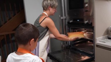 Yemek pişirme becerileri, ilgili anne, sıcak aile mutfağında birlikte ev yapımı sünger keki hazırlarken küçük oğluna un tarlasında rehberlik ediyor.