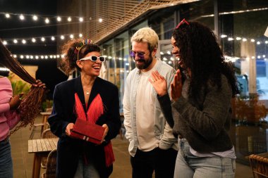 Mutlu çoklu etnik arkadaşlar gece bir doğum günü partisini kutluyor, birlikte gülüyor, neşeli atmosferin tadını çıkarıyor ve neşeli anılar yaratıyorlar.