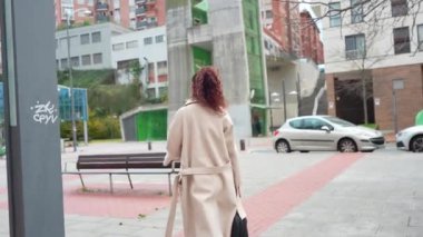 Profesyonel iş kadını dinleniyor, şehir parkında yürüyor ve kentin güz manzarasının ortasında kenarda oturuyor.