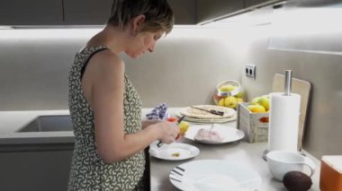 Parlak, modern bir mutfakta patates soyarken yemek için malzeme hazırlarken. Yavaş çekim sürecin ayrıntılarını yakalar