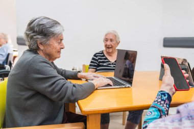 Huzurevindeki yaşlılar dizüstü bilgisayarlar ve akıllı telefonlar da dahil olmak üzere dijital cihazlar kullanıyorlar, destek veren bir ortamda bağlantı ve öğrenmeyi teşvik ediyorlar.
