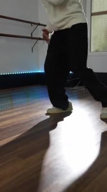 Profesyonel dansçı modern dans stüdyosu ortamında güçlü hareketler ve sanatsal ifadeler sergileyerek dinamik afro hip hop koreografisi sergiliyor.