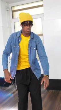 Yetenekli erkek dansçı yaratıcı enerjisi ve tutkulu hareketleriyle parlak dans stüdyosunda dinamik afro hip hop koreografisini ifade ediyor.