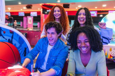 Dört genç arkadaş bir bowling salonunda oyun oynarken gülüp eğleniyorlar.