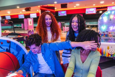 Genç arkadaşlar eğleniyor, atari oynuyorlar ve bowling salonunda birlikte eğleniyorlar.