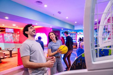 Genç yetişkinler eğlence merkezinde neon ışıklarla oyun oynayarak eğleniyorlar.