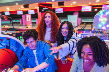 Genç arkadaşlar bowling salonunda atari oynayıp eğleniyorlar. Birlikte boş zamanlarının tadını çıkarıyorlar.