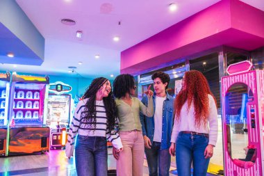 Bir grup genç arkadaş birlikte eğleniyor, renkli bir bowling salonunda ve atari salonunda oynuyorlar.