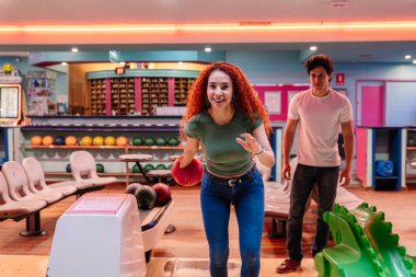 Neşeli arkadaşlar eğlenceli bir bovling gecesinin keyfini çıkarıyorlar, dostça bir dostluk gösterisi ve eğlenceli bir eğlence ortamında dostça bir rekabet.