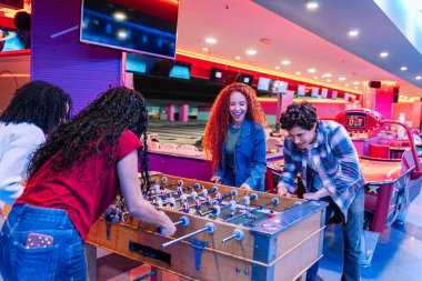 Gençler canlı bir bowling salonunda langırt oynamaktan zevk alıyor, birlikte gülüyor ve eğleniyorlar.