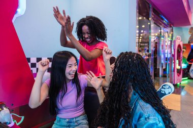 Bir grup genç kız arkadaş eğleniyor, tezahürat yapıyor ve zaferlerini bir bowling salonunda oyun oynarken kutluyorlar.