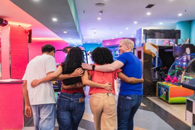 Bir grup arkadaş bovling salonunda ve atari salonunda sarılıp yürüyorlar, birlikte boş zamanlarının tadını çıkarıyorlar.