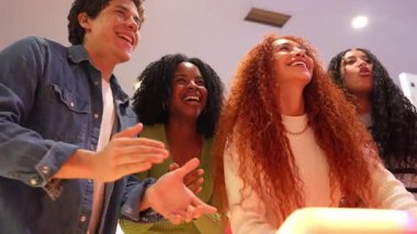 Enerjik bir grup genç arkadaş oyun oynarken yarışıyor ve gülüyor, hafta sonu boş zamanlarında neşe ve arkadaşlık anları paylaşıyorlar.