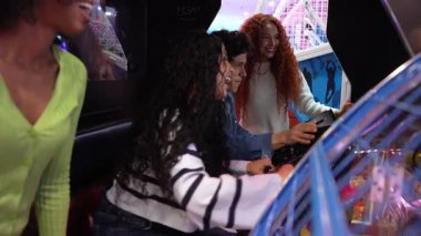 Klasik oyun oynarken enerjik anları paylaşan, neşeli etkileşimleri yakalayan ve canlı ağır çekimde heyecanı paylaşan genç kadınlar.