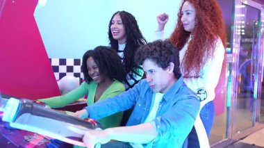 Dört heyecanlı arkadaş, iki erkek ve iki kadın, bir lunaparkta araba yarışı oynuyorlar ve eğleniyorlar.