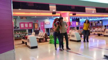 Bowling oynarken genç bayanı destekleyen arkadaşlar, oyun sırasında eğlenceli etkileşimler ve takım arkadaşlığı ile cesaret verici anlar paylaşıyorlar.