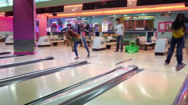 Genç arkadaşlar yüksek enerjiyle bowling grevini kutluyorlar. Bowling salonunda unutulmaz bir anı paylaşırken saf neşe ve heyecan ifade ediyorlar.